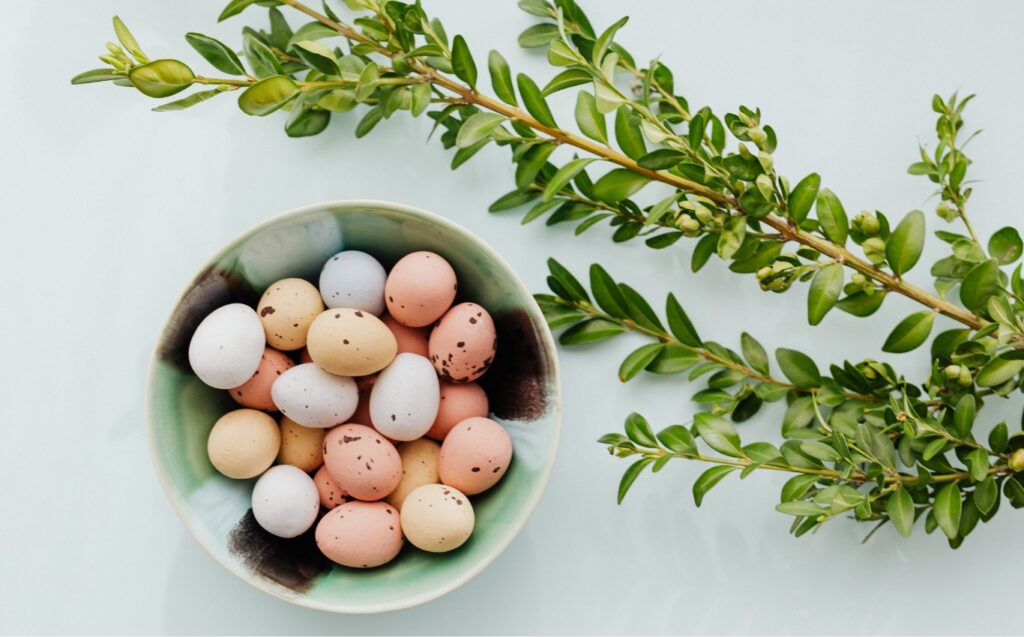 Osternest mit bunten Eiern und Palmzweig