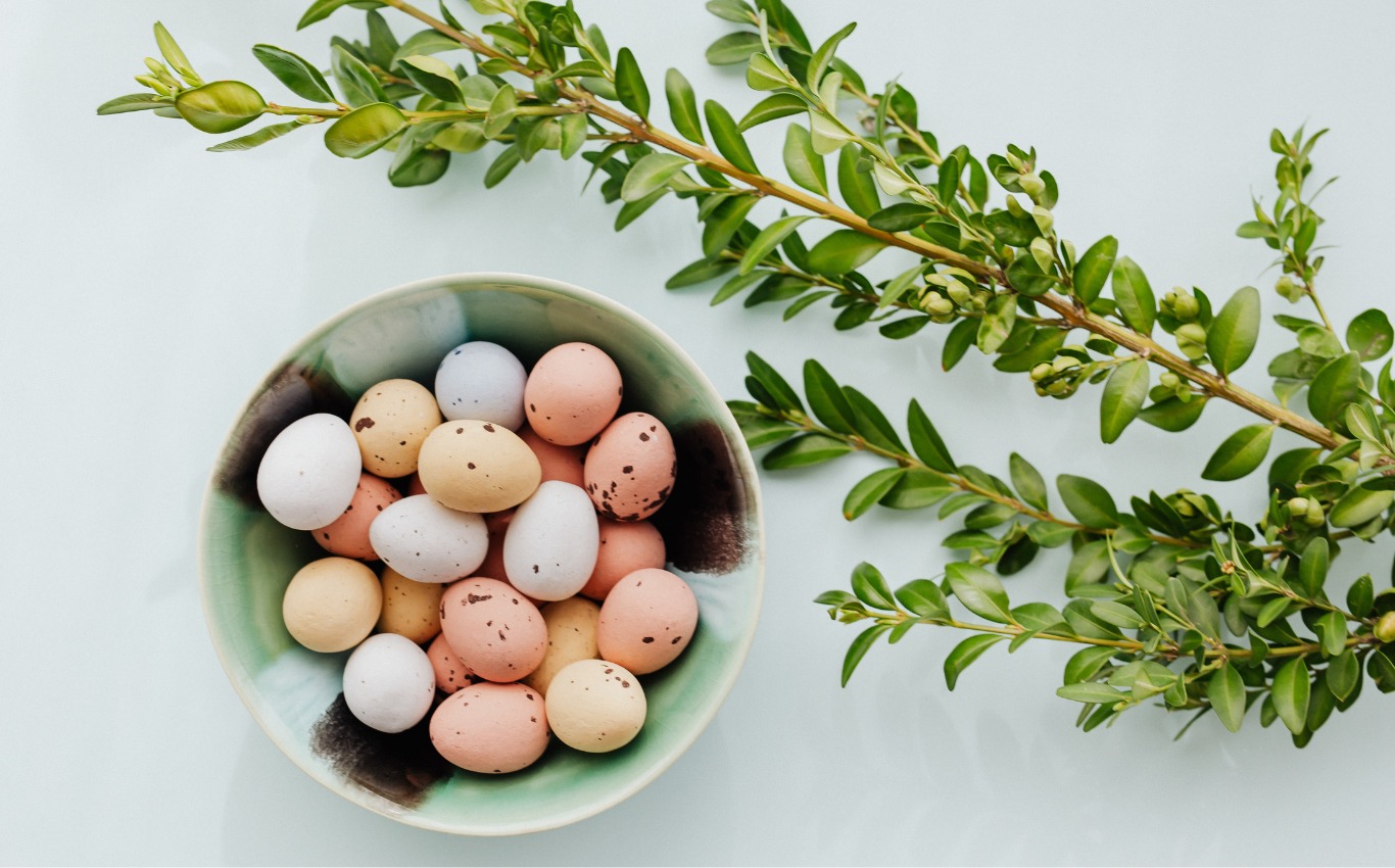 Osternest mit bunten Eiern und Palmzweig