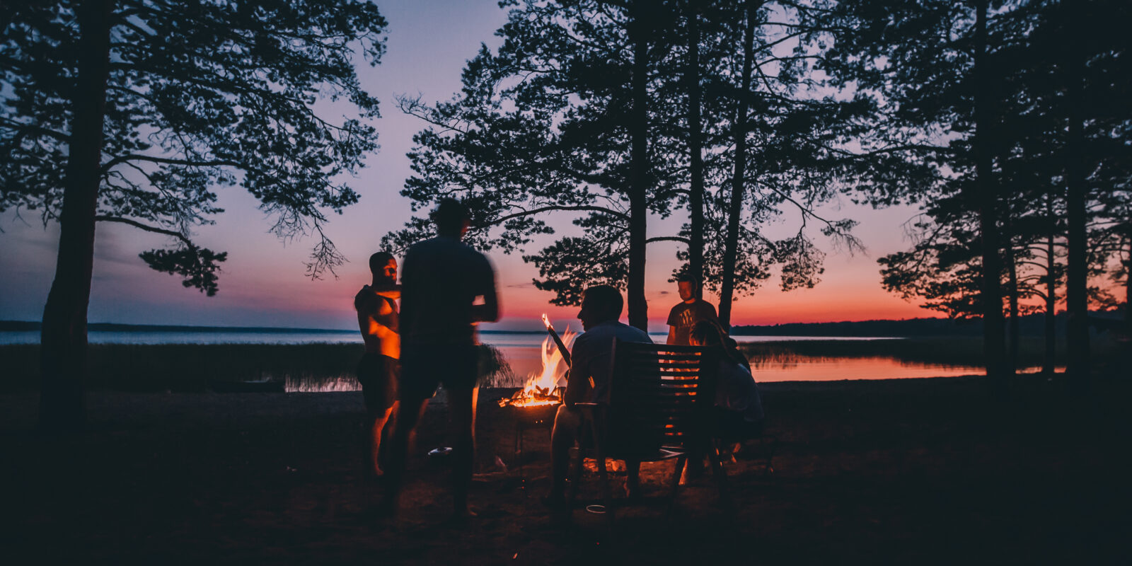 Freunde am Lagerfeuer in der Dämmerung