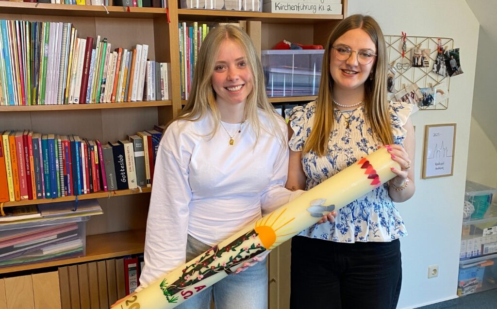 Zwei junge Frauen mit einer gestalteten Osterkerze