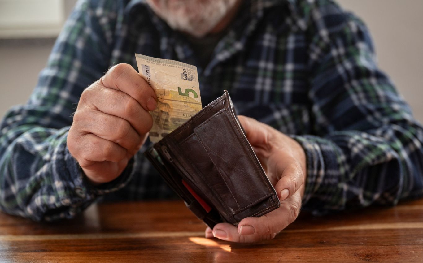 Mann nimmt 5 Euro aus dem Portemonnaie