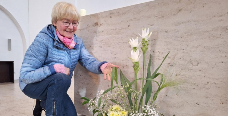Veronika Lausch vor einem Altar mit Blumengesteck