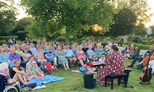 Menschen lauschen einem Konzert auf dem Friedhof in Melle-Wellingholzhausen