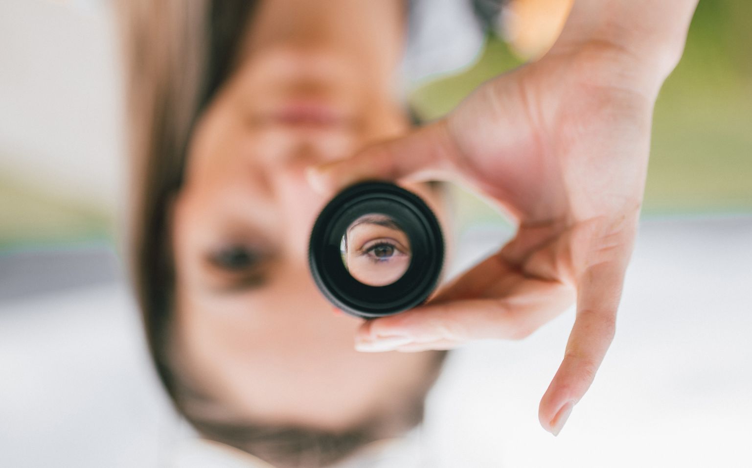Frau guckt durch ein kleines Fernglas