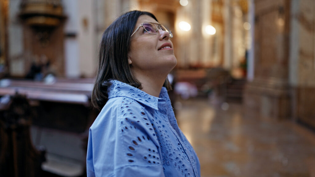 Frau in Kirche mit Brille schaut sich um